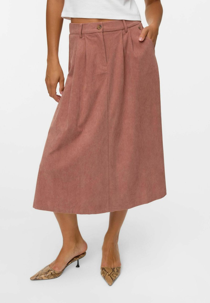 Jupe midi plissée en tissu rose doux ; dotée d'une taille, de deux poches latérales et d'une coupe décontractée. Assortie à des chaussures à bout pointu en imprimé serpent.