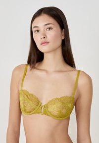 Olijfgroene kanten bralette met bloemenpatronen, met beugelondersteuning, verstelbare bandjes en een detail met sluiting aan de voorkant.