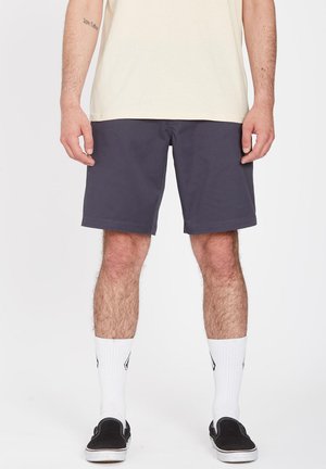 Men's dark gray shorts made from a flexible material. Features a standard fit and subtle stitching. Worn with white socks and black slip-on shoes.