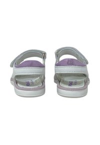 Sandali bianchi con una fascia glitter viola, chiusura regolabile, suola interna testurizzata e suola in gomma liscia. Presentano un design a schiena aperta.