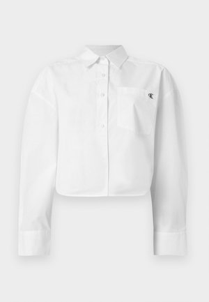 Λευκό cropped πουκάμισο με μακριά μανίκια, κουμπιά, μυτερό γιακά και τσέπη στο στήθος με μικρό μαύρο λογότυπο «ck».