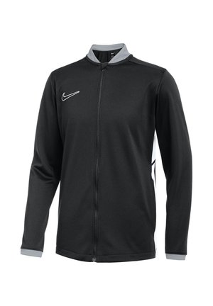Veste Nike noire avec manches longues, fermeture éclair sur le devant, col gris et logo blanc. Présente un panneau latéral contrasté et un tissu texturé.