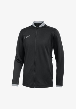 Giacca nera Nike con maniche lunghe, zip frontale completa, colletto grigio e logo bianco. Presenta pannelli laterali a contrasto e tessuto testurizzato.