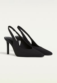 Black slingback heels with a pointed toe, crafted from a smooth material. Features a sleek design and a stiletto heel.