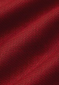 Czerwony tkany materiał o gęstym, jednolitym wzorze, charakteryzujący się gładką teksturą i subtelnym połyskiem. Tkanina ma bogaty, żywy kolor.