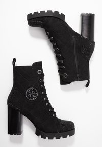 Stivali neri alla caviglia con tomaia in suede e texture trapuntata, accenti di strass, lacci frontali e tacco a blocco largo.