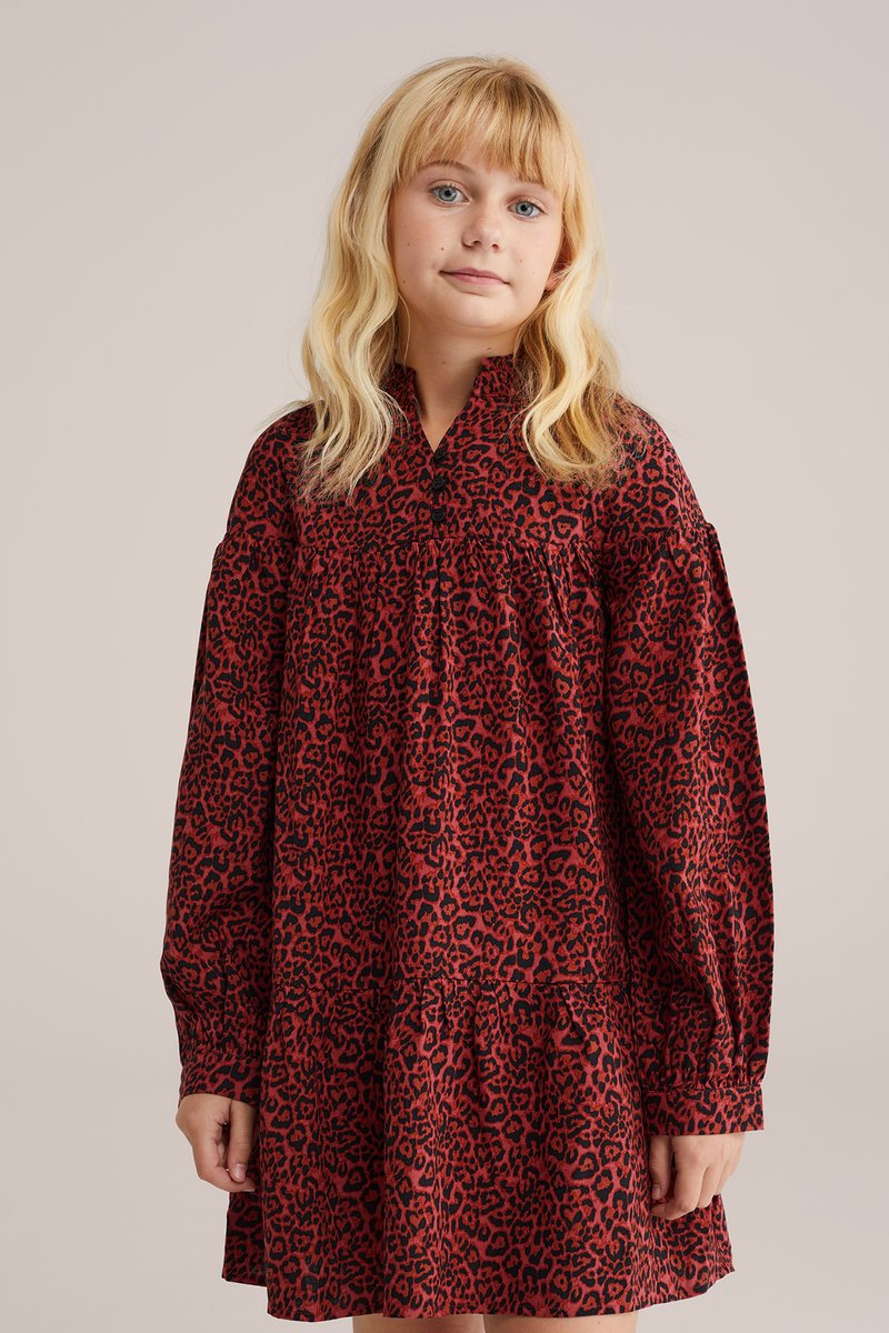 Sarkana leoparda raksta kleita ar garām piedurknēm un savilkta svārku daļa. Tam ir augsts kakla izgriezums un brīvs piegriezums, izgatavota no viegla auduma.