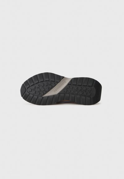 Black sneaker sole with a textured rubber grip, featuring a metallic accent labeled "DSQUARED2" and visible tread patterns for traction.