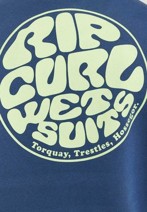 Blaues Gewebe zeigt ein rundes Logo mit großen, hellgrünen Texten, die "RIP CURL WETSUITS" und "Torquay, Trestles, Hossegor" lesen.