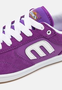 Μωβ σουέτ αθλητικά παπούτσια με λευκές κορδόνες, διαθέτουν λευκή δερμάτινη λογότυπο και επενδεδυμένη γλώσσα με ετικέτα επωνυμίας. Ελαστική σόλα.