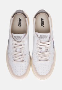 Sneakers bianchi in pelle con punta perforata, accenti in suede beige, lacci crema e tallone grigio. Logo "AUTRY MEDALIST" sulla linguetta.