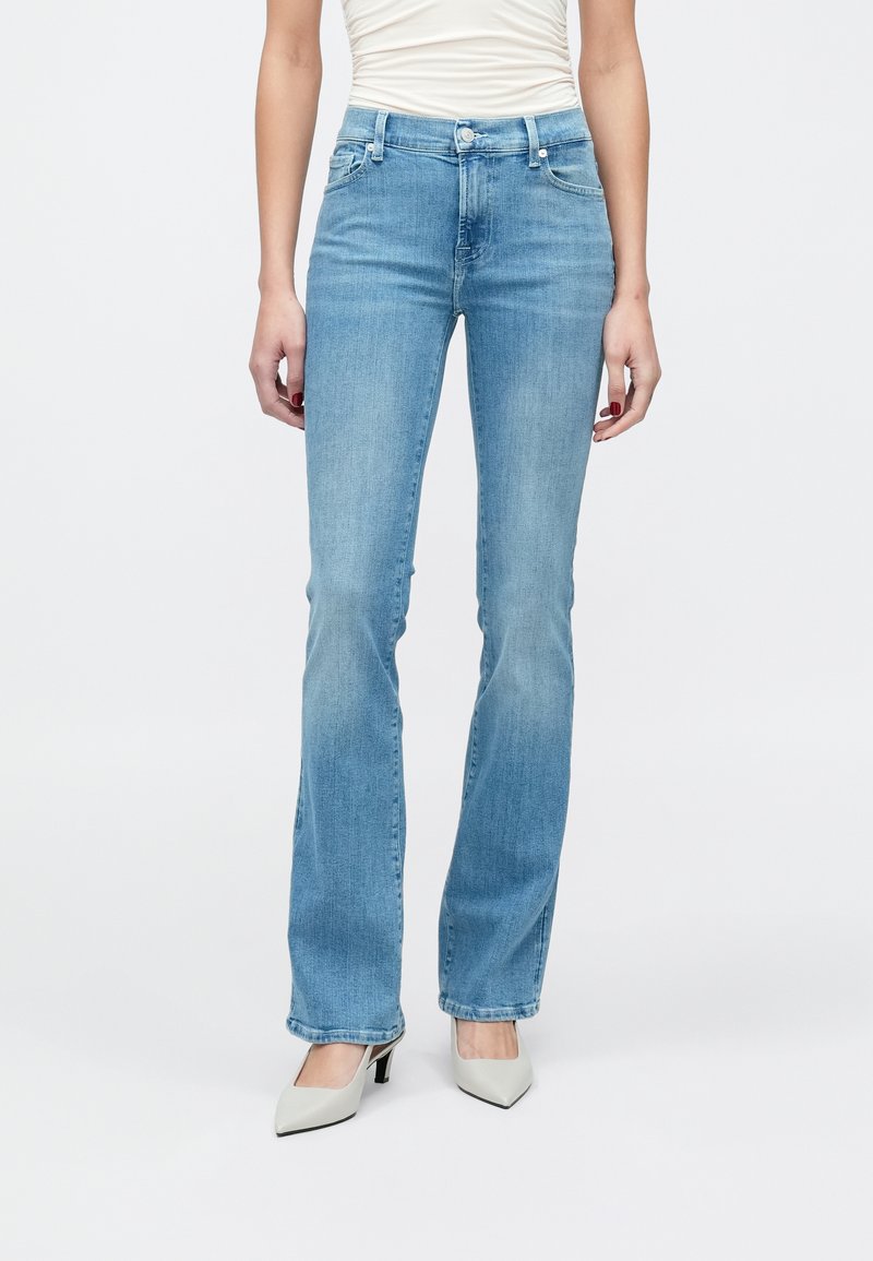 Világoskék farmerkék színű, bővülő szárú farmernadrág közepes derékmagassággal, öt zsebbel és patentos sliccel. Az anyag enyhén kopott hatású, sima tapintású.