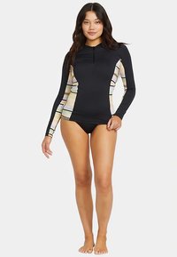 Camisola de proteção preta de manga comprida com painéis laterais às riscas multicoloridas, fecho de correr frontal até ao peito e corte ajustado. Combinada com calções de banho pretos.