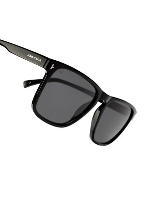 Black sunglasses with square lenses, sturdy plastic frame, and dark tinted lenses. Features logo on the temples.