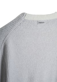 Pull gris clair avec texture côtelée et un col blanc contrastant. Présente une étiquette à l'arrière et un design de manches raglan.