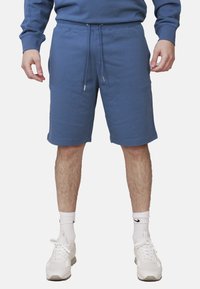 Pantaloni kaki in cotone blu con vita elasticizzata, cordino regolabile, tasche laterali e una consistenza liscia, che terminano appena sopra il ginocchio.