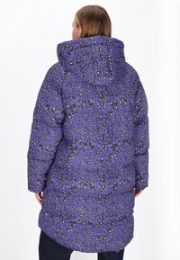 Lila Pufferjacke mit Leopardenflecken in Schwarz und Lime. Verfügt über eine Kapuze und ein leicht Übergröße-Design für zusätzlichen Komfort.