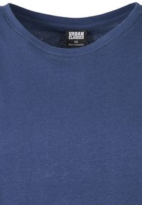 Navy blue crew neck t-shirt with "Urban Classics" brand label showing size XS and "Made in Bangladesh" text.