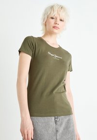 Alyvuogių žalios medvilnės marškinėliai su apvalia iškirpte, trumpomis rankovėmis ir balta "Pepe Jeans London" logo priekyje.