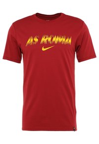 Camiseta roja de manga corta hecha de algodón con gráfico amarillo "AS ROMA" y logo de Nike. Presenta un cuello redondo y un ajuste estándar.
