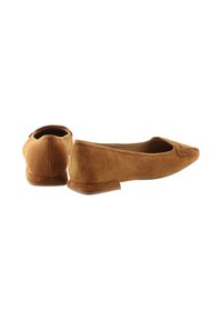 Suede flats in tan, pointed toe design with stitched accents on the front. Low heel and smooth texture, with minimalistic shape and profile.