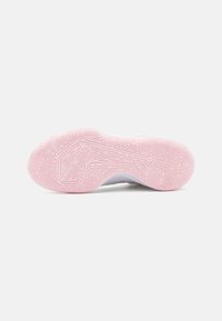 Sulan på en sko med ett rosa gummi-material, som har en texturerad yta och geometriska mönster för grepp och fäste.