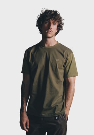 Olive green short-sleeve t-shirt with a round neckline and textured shoulder accents. Features a small elephant logo on the chest.
