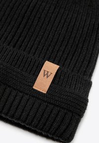Cappellino beanie nero lavorato a maglia con texture a coste e risvolto pieghevole. Presenta una piccola etichetta in pelle marrone con la lettera "W".
