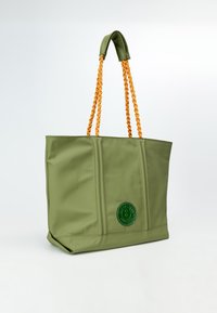 Borsa tote in nylon verde con manici arancioni intrecciati, caratterizzata da un logo circolare verde e dettagli di cucitura verticale.