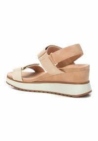 Sandalias de cuña beige con doble correa, que presentan una suave textura de ante y una suela blanca de plataforma con detalles de diseño antideslizante.