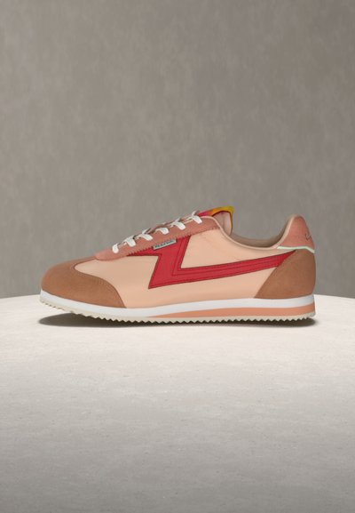 Χαμηλό προφίλ αθλητικού παπουτσιού με ροζ, κόκκινα και καφέ πάνελ, λευκά κορδόνια και λευκή σαγρέ σόλα, εμφανιζόμενο σε απλή επιφάνεια.