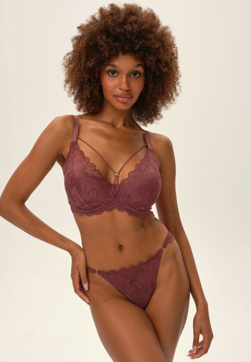 Bordowy zestaw bielizny koronkowej z kwiatowymi wzorami. Biustonosz z regulowanymi ramiączkami, fiszbinami i falbankami. Pasujące koronkowe stringi.