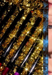 Set of black lip liners placed against a background of shiny gold sequins, with hints of red and purple on two lip liners.