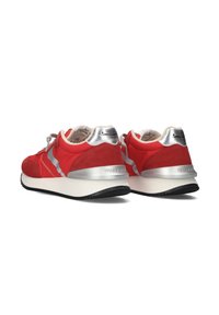 Red sneakers featuring suede and mesh materials, silver accents at the heel and side, flat black rubber sole, and textured laces.