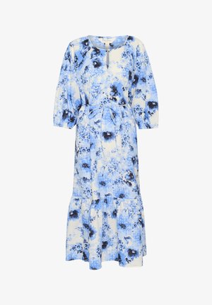 Cvetna maksi obleka v modri in beli barvi z večnivojsko obrobo. Ima okroglo izrez, rukavov do tri četrtine in zavezan pas za prilegačen videz.