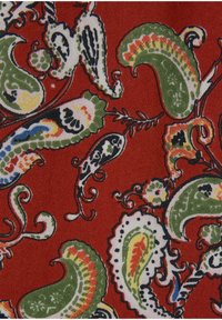 Roter Stoff mit einem Paisleymuster, das grüne, gelbe, schwarze und weiße Akzente aufweist. Glatte Textur mit aufwendigen, wirbelnden Designs.