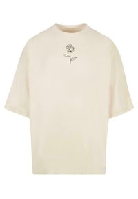 Kortermet, kremfarget T-skjorte laget av myk stoff. Har et minimalistisk svart linjetegning av en rose på brystet. Avslappet passform.