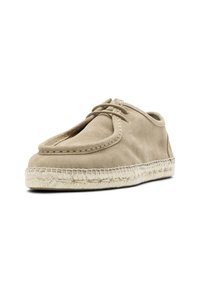 Beige mockasinstil sko i mocka med snören och en tjock, flätad rep-sula, vinklad något åt höger på vit bakgrund.