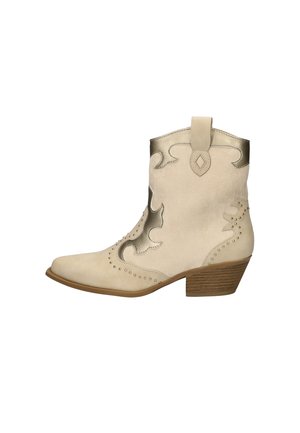 Beige cowboylaars van suede met metallic accenten. Heeft gebogen decoratieve stitching en een kleine gestapelde hak. Puntige neusontwerp.