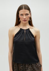 Black satin halter top featuring a keyhole detail at the front and a gathered neckline. Smooth texture with a subtle sheen.