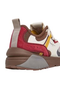 Baskets avec un dessus en daim rouge et en maille marron, semelle grise et accents jaunes. Comprend une languette et un détail de logo.