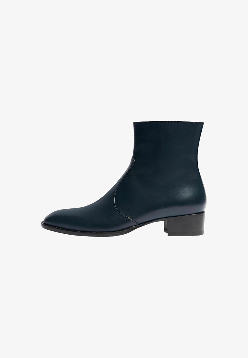 Botas de piel de color azul oscuro hasta el tobillo con un acabado suave, punta afilada y un tacón bajo y cuadrado. Presentan una costura lateral para un diseño elegante.