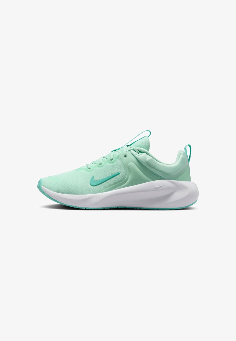 Chaussure de course Nike vert clair avec semelle blanche épaisse, design à lacets et petit swoosh Nike sur le côté et la semelle.