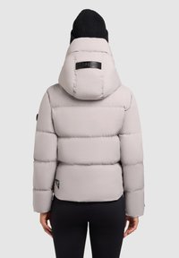 Puffertjakke i lys grå med quiltede sektioner, høj krave og aftagelig hætte. Sort mærke på ryggen.