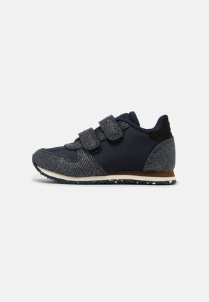 Baskets de sport marine avec un tissu texturé, des sangles Velcro et une semelle en caoutchouc contrastante. Présente des accents métalliques et un col rembourré.