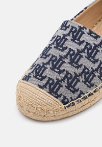 Blå och vit espadrille-sko med vävd kanvasövre som har ett mönstrat design och sula i jute-rep. Rundad tå med sömsdetaljer.