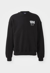 Hanorac negru din bumbac, cu guler rotund, manșete și tiv din tricot. Partea din față afișează "1894" și "House Of" în text alb.