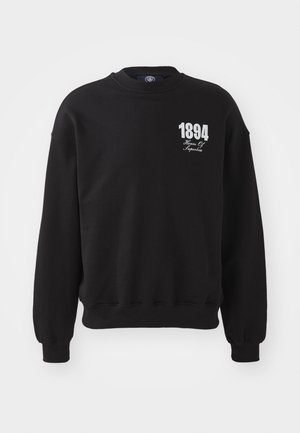 Svart sweatshirt laget av bomull, med rund hals, ribbestrikkede mansjetter og nederkant. Fronten viser "1894" og "House Of" i hvit tekst.