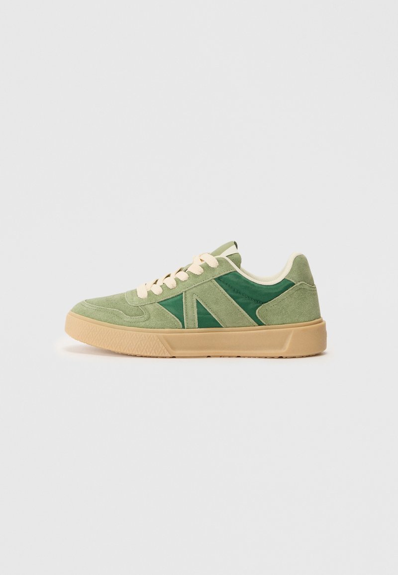 Grønne ruskindsneakers med en blanding af lyse og mørkegrønne paneler, cremefarvede snørebånd og en tekstureret beige gummisål.