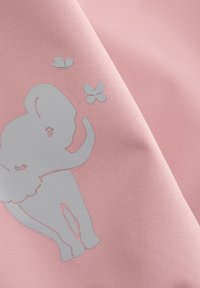 Rosa tyg med en silverfärgad elefantdesign med upphöjd snabel, tillsammans med två silverfärgade fjärilar, på en texturerad yta.